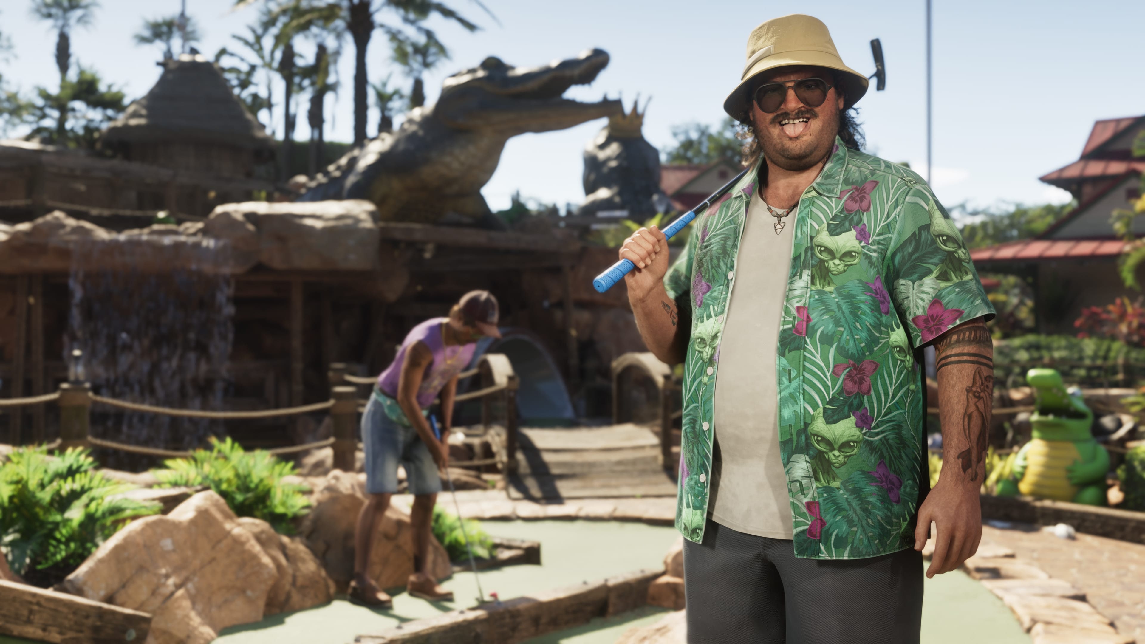 Homme en chemise hawaïenne, club sur l'épaule, sur un mini-golf décoré d'un alligator géant